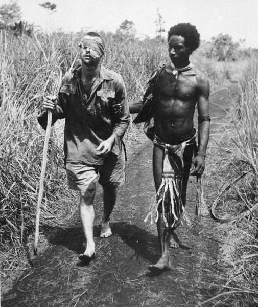A wounded Australian soldier is aided by a Papuan orderly named Raphael Oimbari, during the Battle of New Guinea, near Buna. December 25, 1942 [505 x 600]