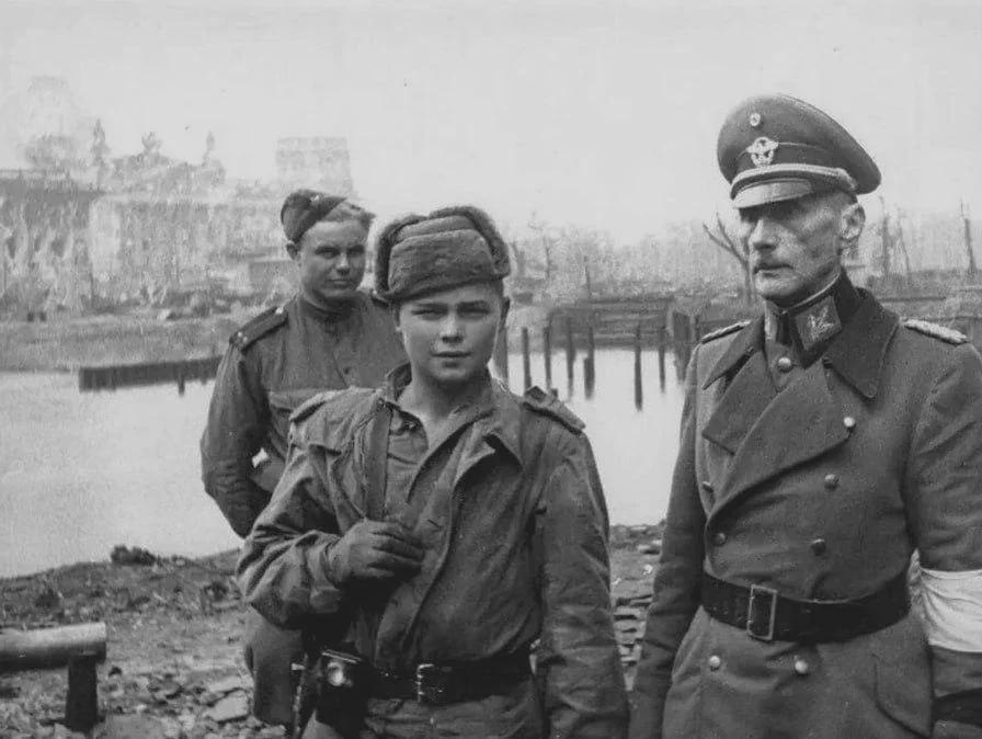A German General and a young Soviet boy who took him prisoner, Berlin, 1945. [896×764]