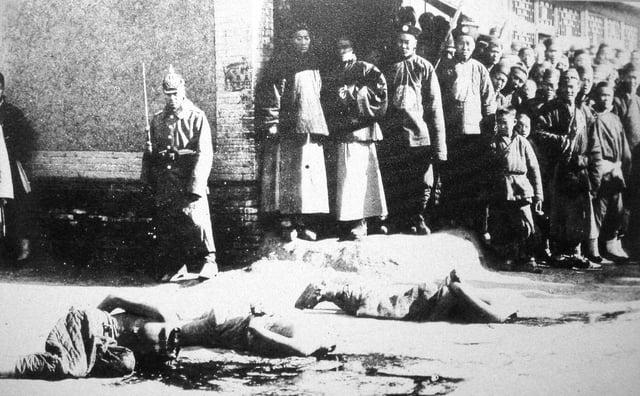German soldier looking at the body of a beheaded Boxer in 1901 [769 x 604]