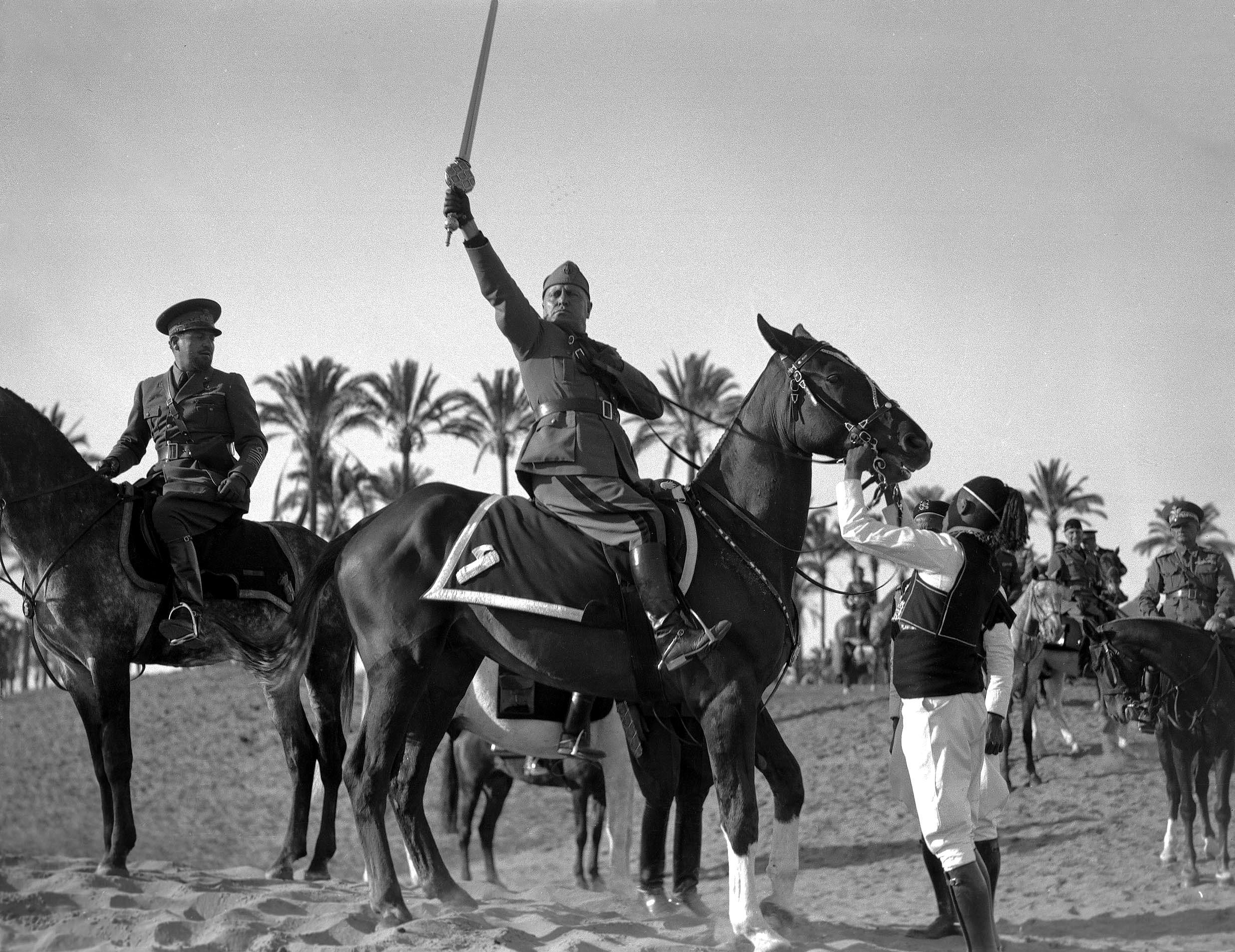 1937 photo of Italian dictator & ‘Protector of Islam’ Benito Mussolini brandishing ‘The Sword of Islam,’ a ceremonial weapon given to him during a propaganda campaign meant to endear him to the Muslim population of Italian Libya. These attempts were very poorly received by the locals (2474×1908)