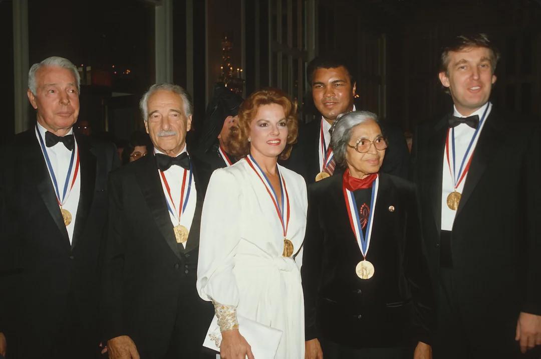 Joe DiMaggio, Victor Borge, Anita Bryant, Muhammad Ali, Rosa Parks, and Donald Trump receive the Ellis Island Medal of Honor. 27 October 1986, New York. [1900×1261]