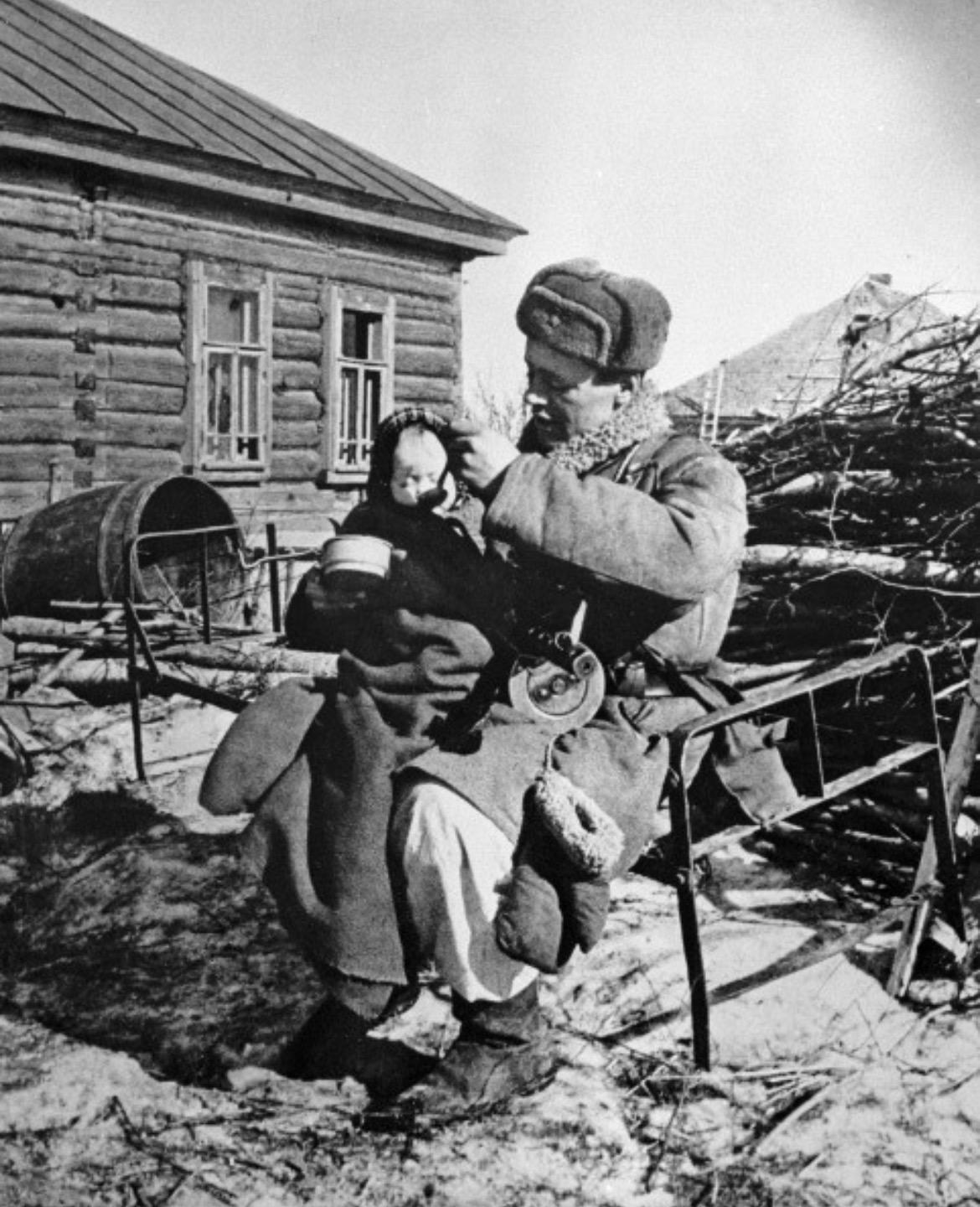 A Red Army soldier holds a baby whose mother was killed, 1943, Russia. [1170 x 1440]