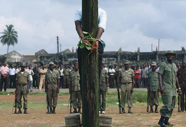 A young Armed Forces of Liberia (AFL) soldier accused of looting and murder is bound to a telegraph pole before facing the firing squad. Photo by Patrick Robert (November 21st, 1992) [612×419]