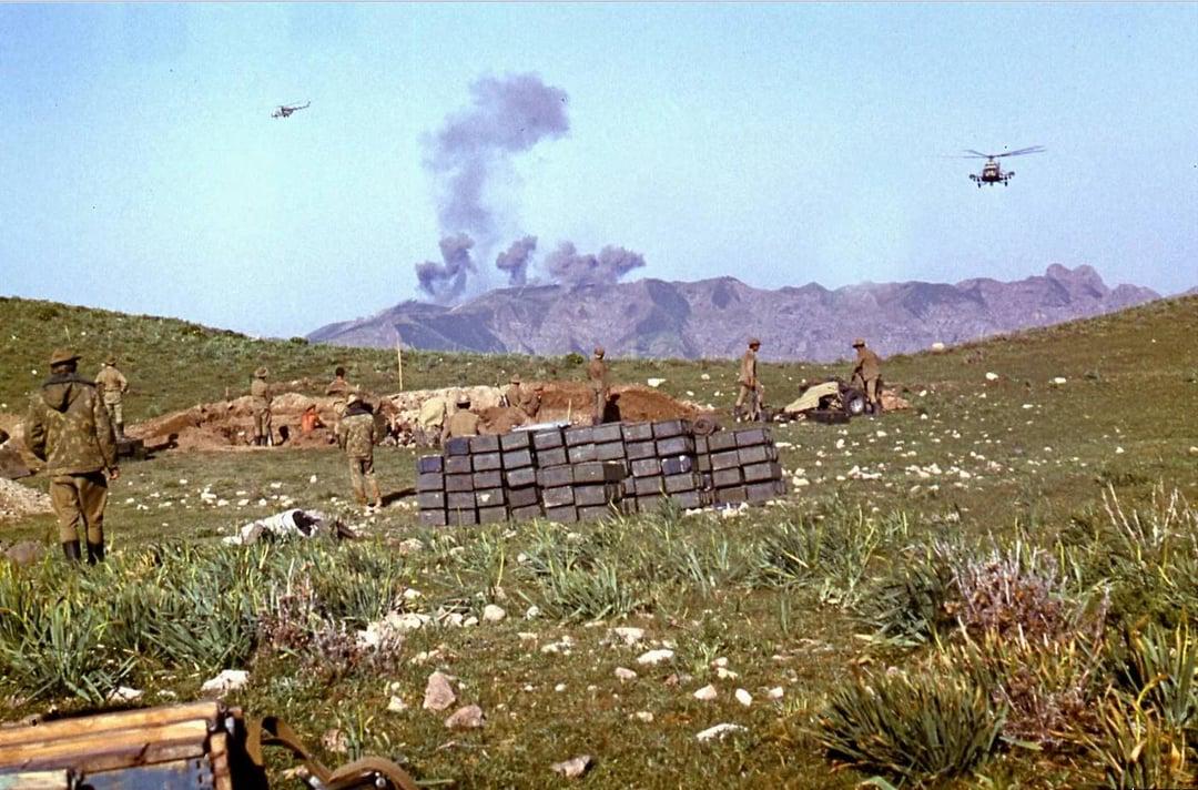 Soviet soldiers watching from afar as attack helicopters strike on Mujahideen positions in Afghanistan (1985) [1401×924]
