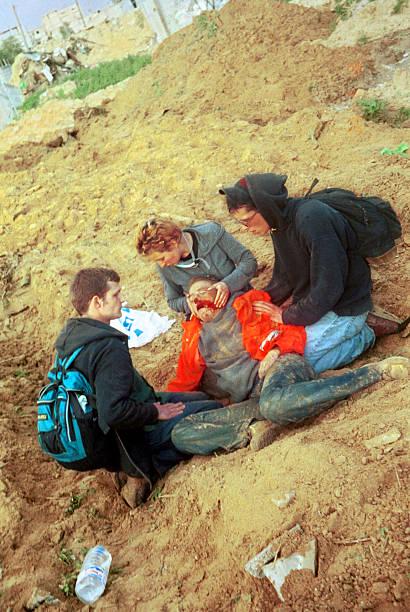 American peace activist Rachel Corrie, lies bleeding while being helped by colleagues after she was run over and killed by an Israeli bulldozer when she tried to stop it from destroying a Palestinian house in Rafah camp. March, 2003 [612 x 410]
