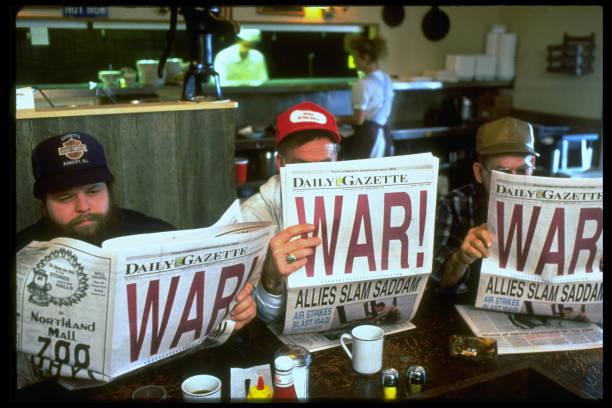 Trio of men reading WAR headlined newspapers at start of the first Gulf War [1/17/1991] (612×408)