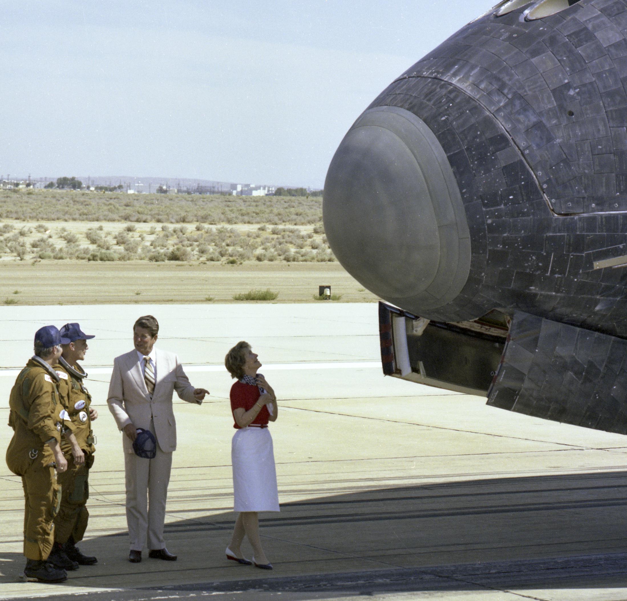 US President Ronald Reagan chats with NASA astronauts Henry Hartsfield & Thomas Mattingly on the runway as first lady Nancy Reagan examines the nose of space shuttle Columbia following its Independence Day landing at Edwards Air Force Base on July 4, 1982. (2198×2107)