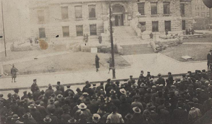 A white mob, consisting of thousands of people, many of whom are hoping to participate in or witness a lynching, stands outside the courthouse as a black man stands trial for murdering a white girl. At least one person in the crowd was seen carrying a rope, Kentucky, 1920. [740 × 435].
