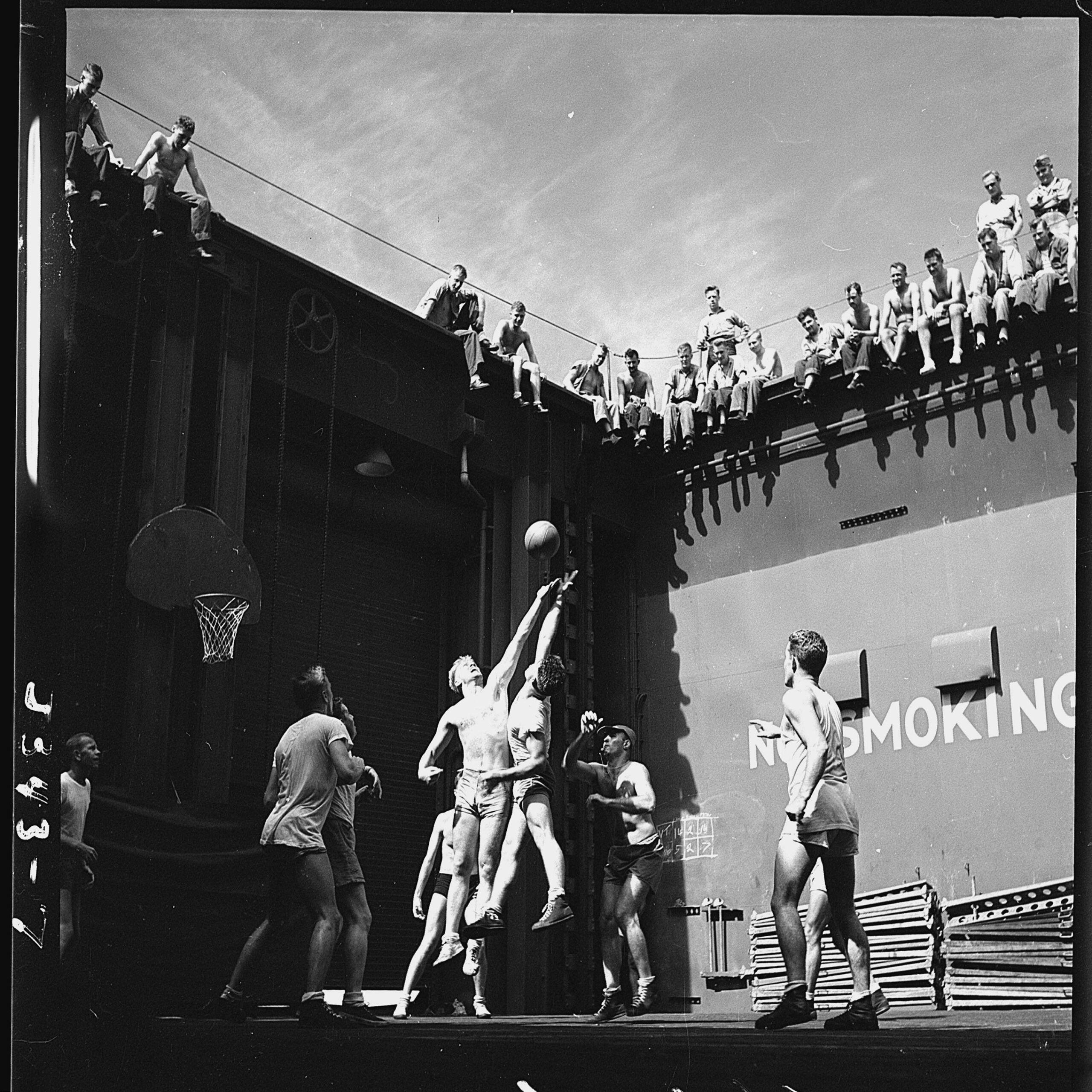 Activities aboard USS Monterey (CVL-26). Navy pilots in the forward elevator well playing basketball. The jumper on the left is future US President Gerald Ford. Photographer: Lt. Victor Jorgensen, June 1944. [2700×2700]