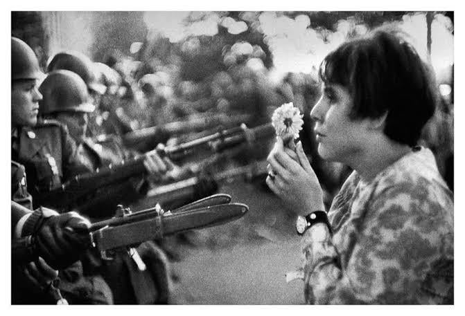 Jan Rose Kasmir, 17, offering a flower to soldiers during the anti-Vietnam war protest at the Pentagon, 1967. Photograph by Marc Riboud. [900×600]