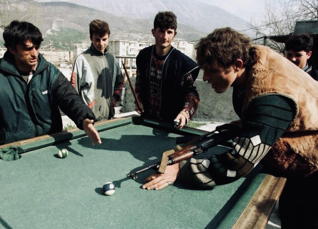 Albanians playing pool with an AK-47 during the Albanian Civil War (1997) [1080×778]