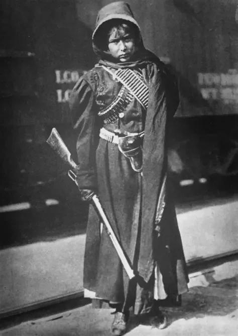 Soldadera posing with her rifle besides Train, Mexico, 1914. [474×669]