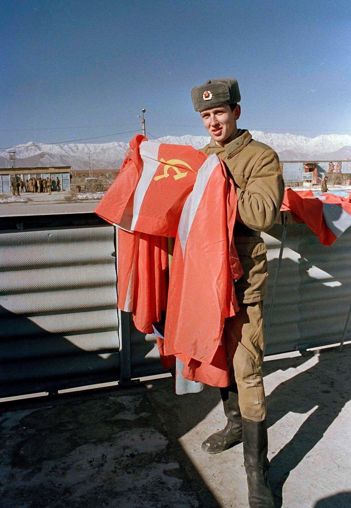 A Soviet invader stationed at Bagram Airfield folding up the flag of the USSR in preparation of the withdrawal from Afghanistan, 1989. (1196×1732)