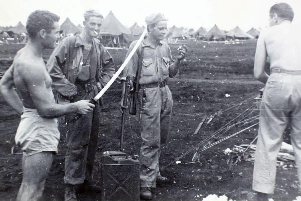 Lt. Cmdr. Gerald R. Pearson displaying the “spoils of war” after the Battle of Iwo Jima, March 1945. [1200×803]