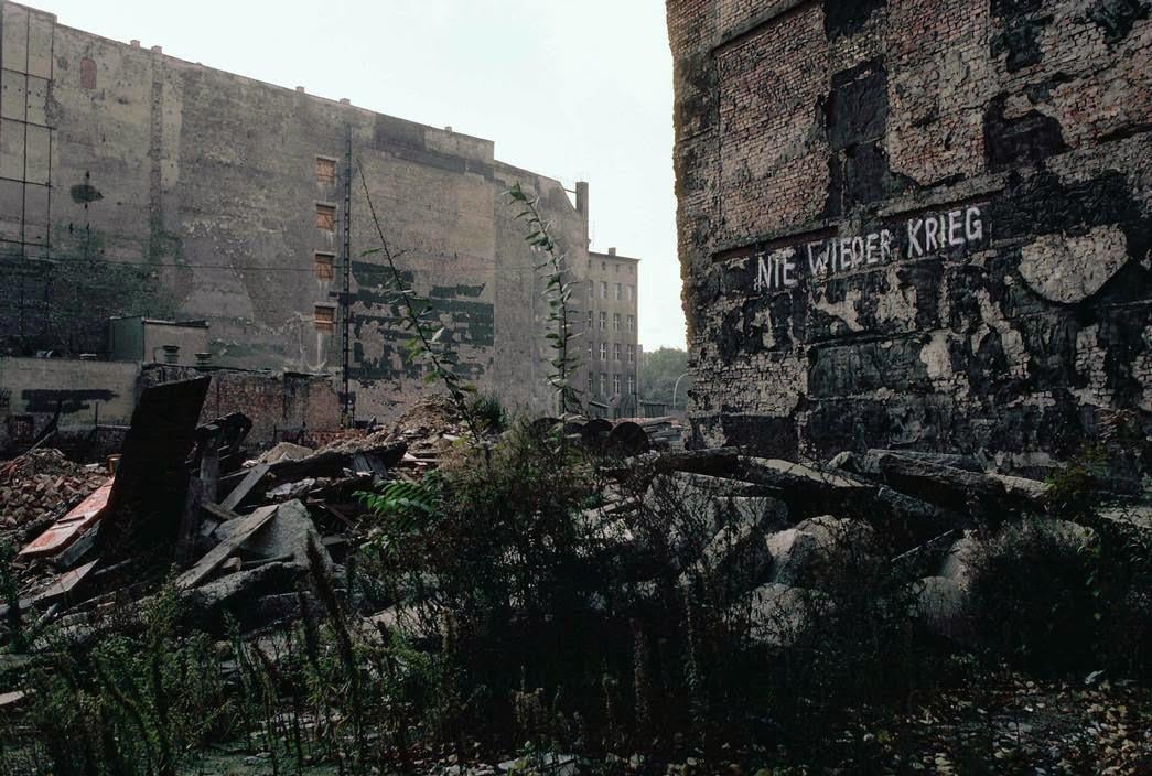 Ruins from the Second World War, laying between buildings with the inscription “Never Again War” (Nie Wieder Krieg) – in East Berlin, German Democratic Republic (GDR), c. 1974. [1045 x 704]