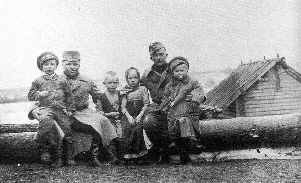 Carelian children on the knees of Finnish soldiers. Picture taken by soldier A. Peltola during the Aunus expedition, part of the Heimosodat. Aunus, Karelia. 1919 [800×488]