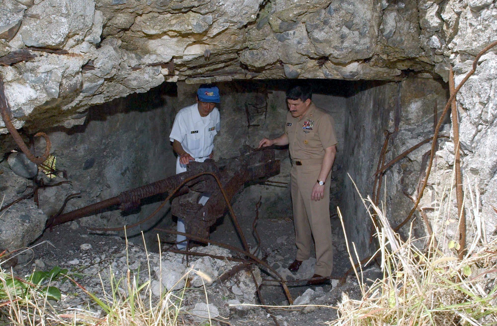 U.S. Navy Master Chief Petty Officer (MCPO), Terry Scott looking at a Japanese Type 96 (25mm) anti-aircraft and anti-tank cannon – in a small cave on the island of Iwo Jima, Japan, c. March 23rd, 2003. [2000 x 1312]