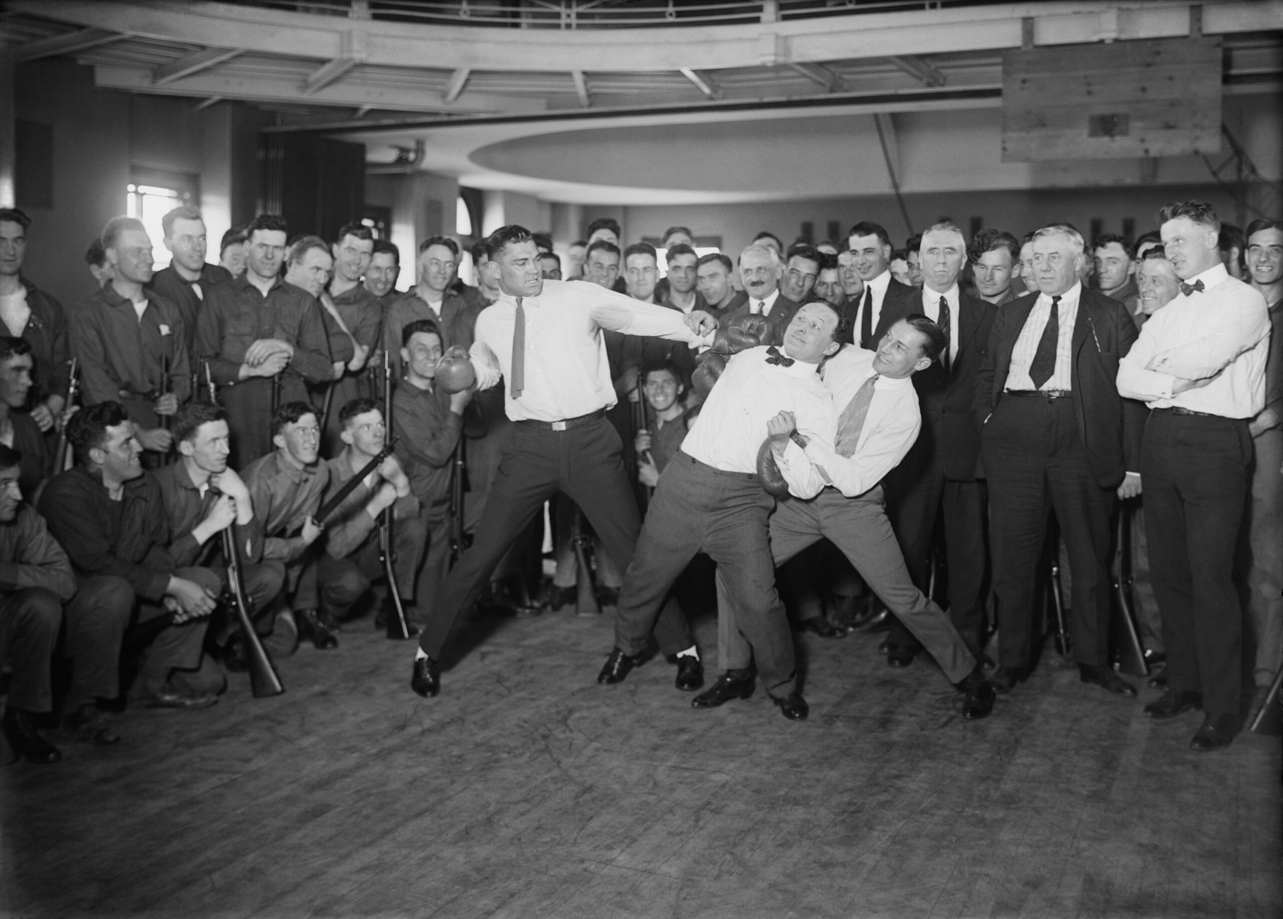 Heavyweight boxer Jack Dempsey mock-punching magician Harry Houdini (held back by lightweight boxer Benny Leonard). circa 1920s. [4726×3385]