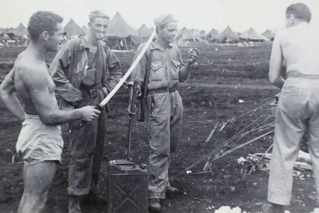 Lt. Cmdr. Gerald R. Pearson displaying the “spoils of war” after the Battle of Iwo Jima, March 1945. [1080×722]