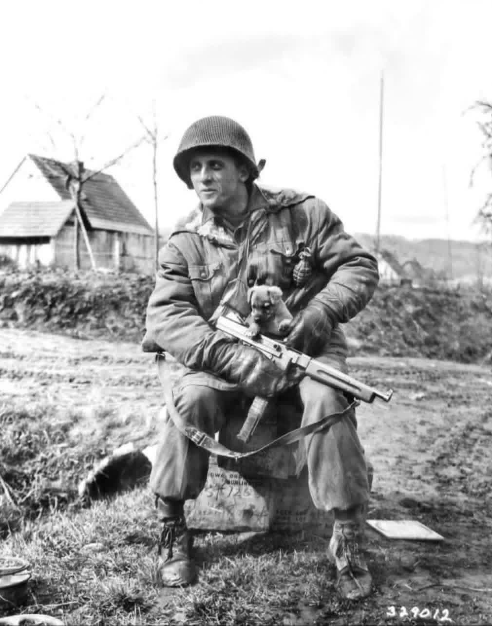 In April of 1945, paratrooper Harry Lorenzo of the 509th Parachute Infantry Battalion clutches his Thompson submachine gun and his puppy “Kaput” near Katharinenberg, Germany. [1010×1286]