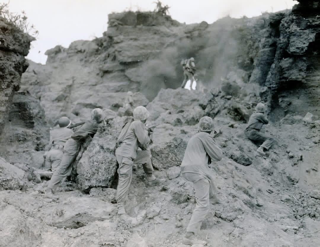 Marines of the 5th Division provide covering fire while a demolition team works against a Japanese position on Iwo Jima in February 1945. Flamethrowers, grenades, and demolitions were used throughout the battle to clear caves, pillboxes, and fortified volcanic terrain. [1080×832]