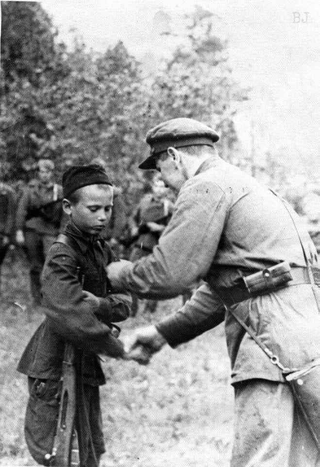 A partisan detachment commander awards the Medal for Courage to 14-year-old Pyotr Ustinovich Gurko. Pskov-Novgorod partisan zone, July 30, 1942. [659×960]