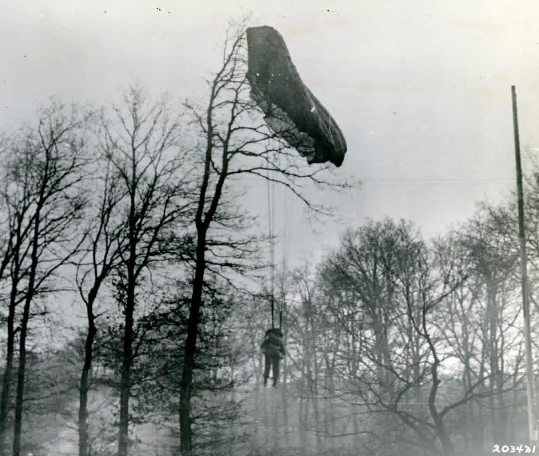 A dead US Paratrooper of the 17th Airborne Division suspended from his parachute in a tree near Wesel, Germany during Operation Varsity – March 24, 1945 [1080×914]