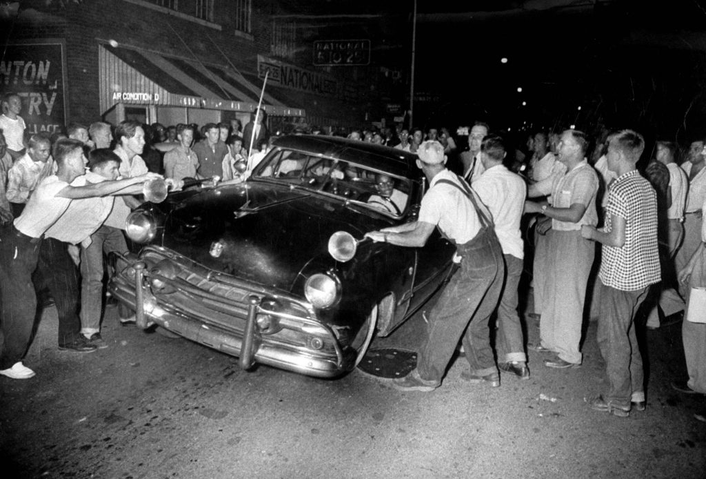African American gentleman tries to navigate his car as anti-integration mob shakes and almost lifts one side of his car, Clinton, Tennessee, 1956 [694×1024]