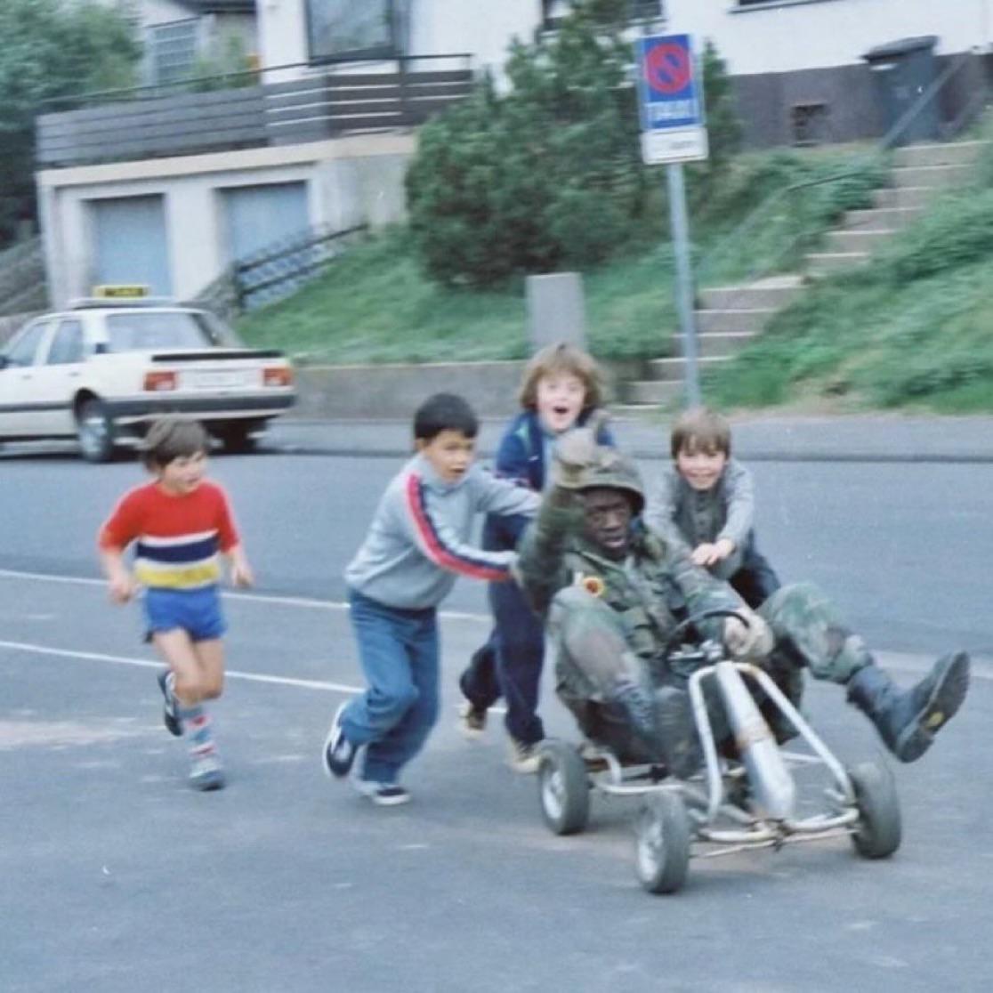 U.S. soldier playing with local german kids on a cart in west germany, (1980s) [1116×1116]