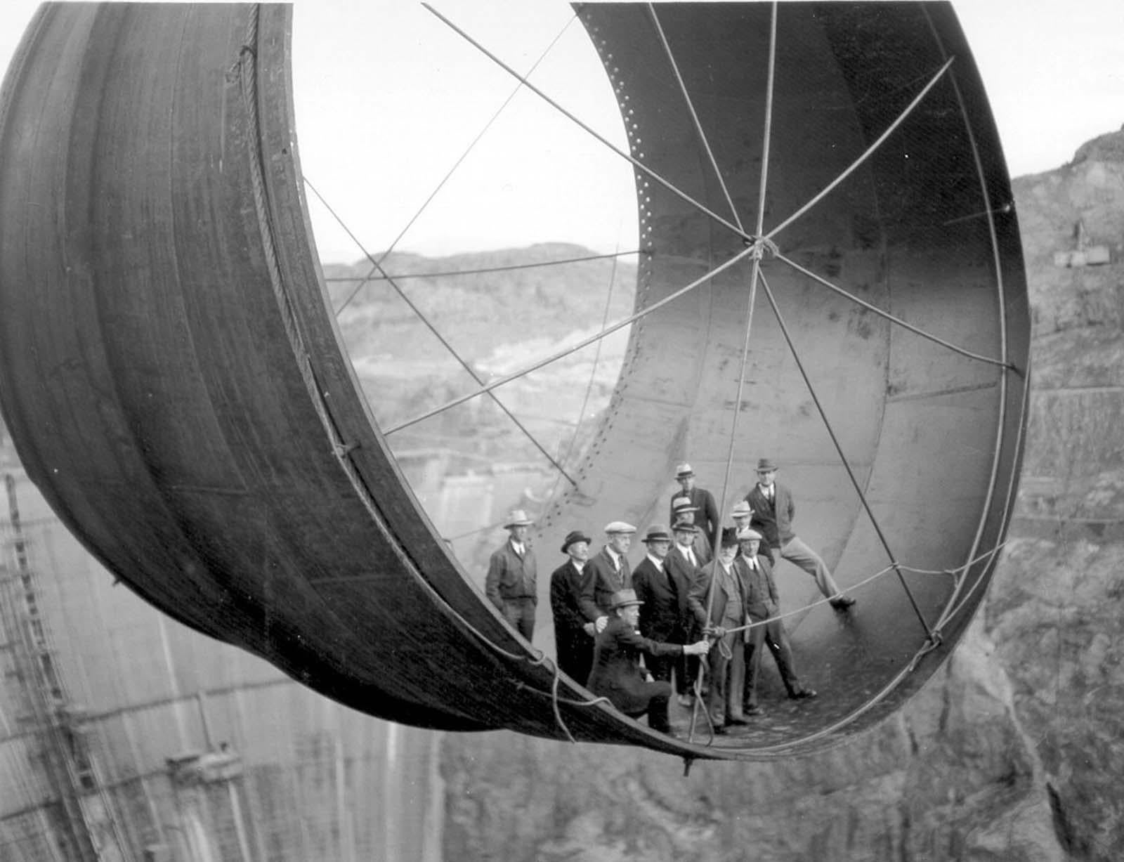 Officials ride in one of the penstock pipes of the soon-to-be-completed Hoover Dam; 1935 [1600×1227]