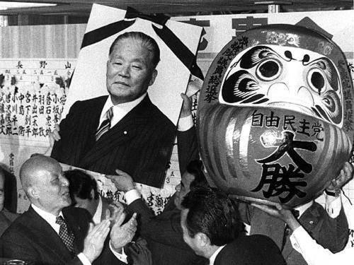 LDP celebrates victory with a memorial portrait of Prime Minister Masayoshi Ohira, who died during the campaign ,and a daruma, Japan, 1980 [500 x 375]