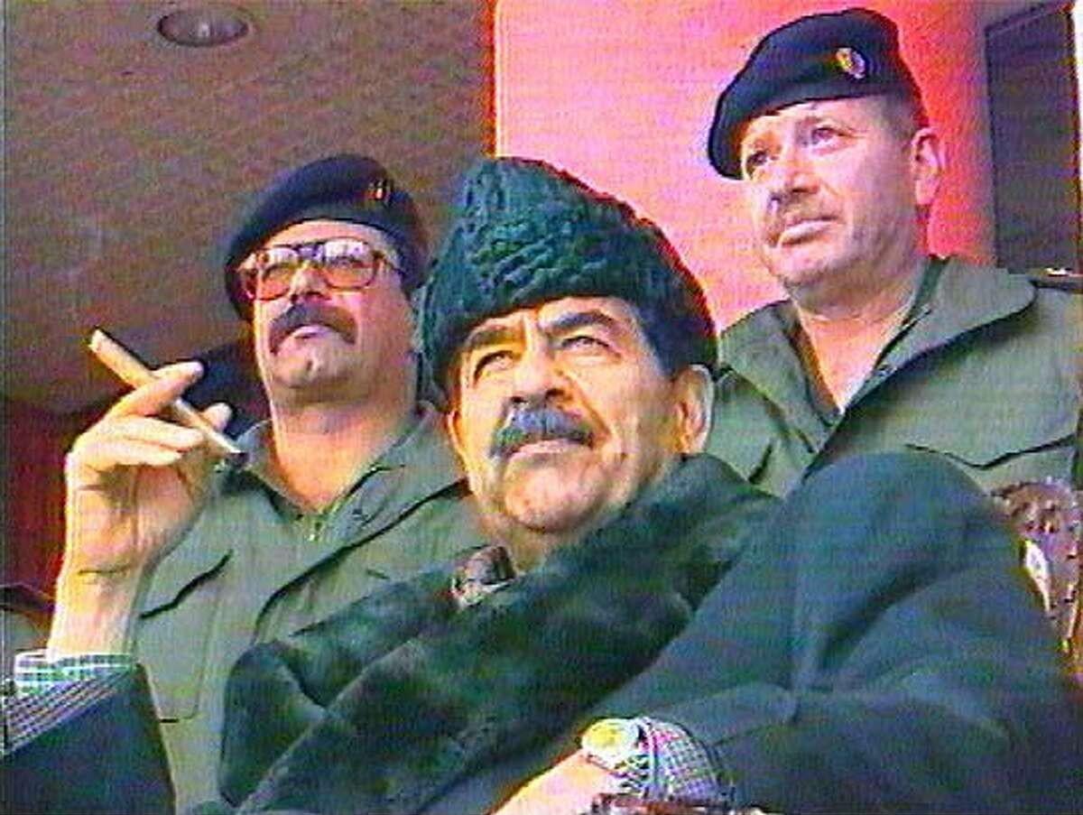 Iraqi dictator Saddam Hussein surveying a parade with his bodyguards during the last day of the Eid al-Fitr festival marking the end of Ramadan, 1999. (1200×903)