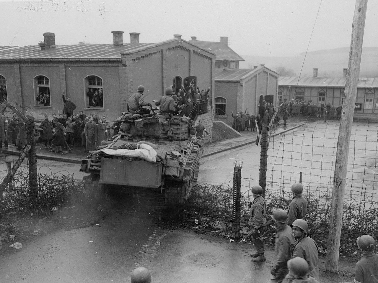 In April of 1945, a 14th Armored Division tank crashes the gate at the Stalag XIII-C POW camp in Hammelburg, Germany. [1280×960]