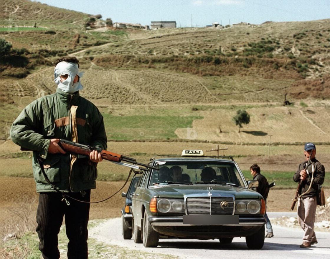Albanian rebels with rifles taken from army storage, at a “checkpoint” on a rural road – during the civil unrest throughout Albania, c. January – August 1997. [1120 x 880]