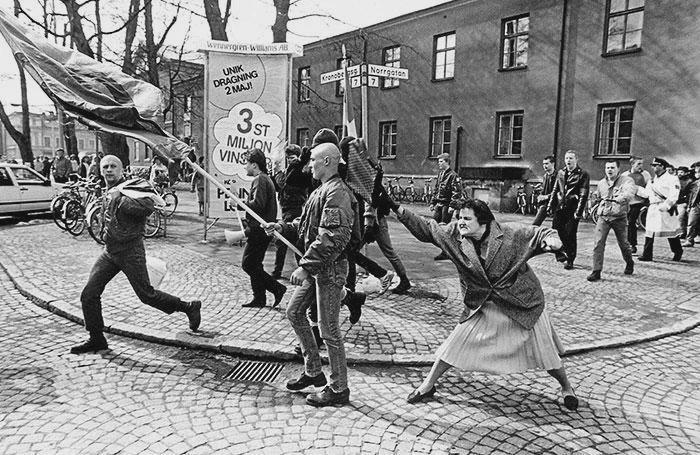 “The Woman with the Handbag” – A 38-year-old woman, Danuta Danielsson, hits a marching Neo-Nazi with a handbag in Växjö, Sweden. April 13, 1985. [700×455]