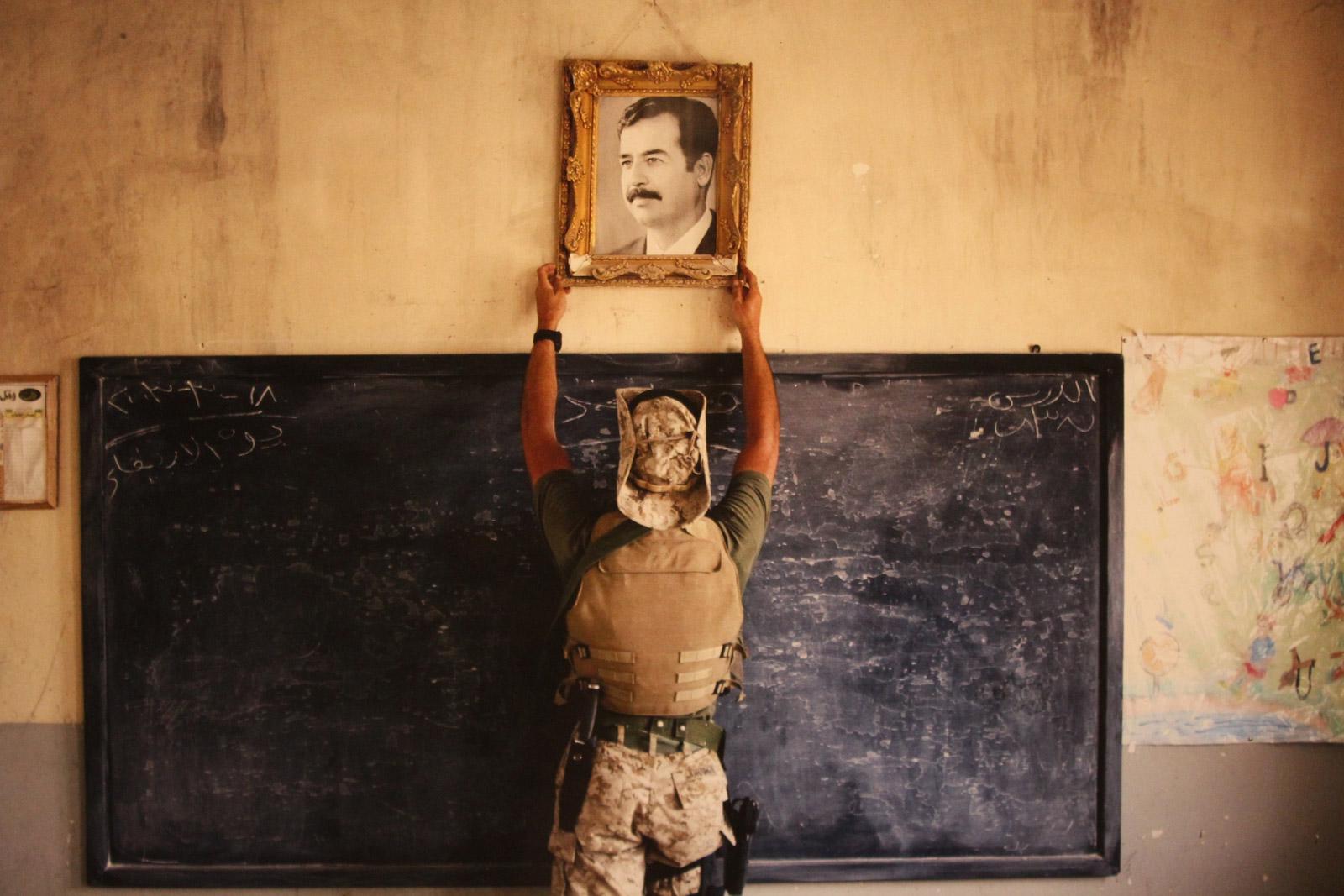 A US Marine pulls down a picture of former Iraqi President Saddam Hussein at a school in Al Kut, Iraq, April 2003.[1600×1067]