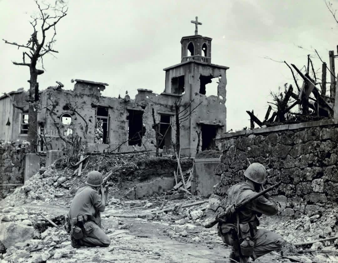 Two Marines keep an eye out for a Japanese sniper in the ruins of a Church near the Shuri Castle on Okinawa while a patrol moves in from the rear to take him out – Late May 1945 [1080×841]