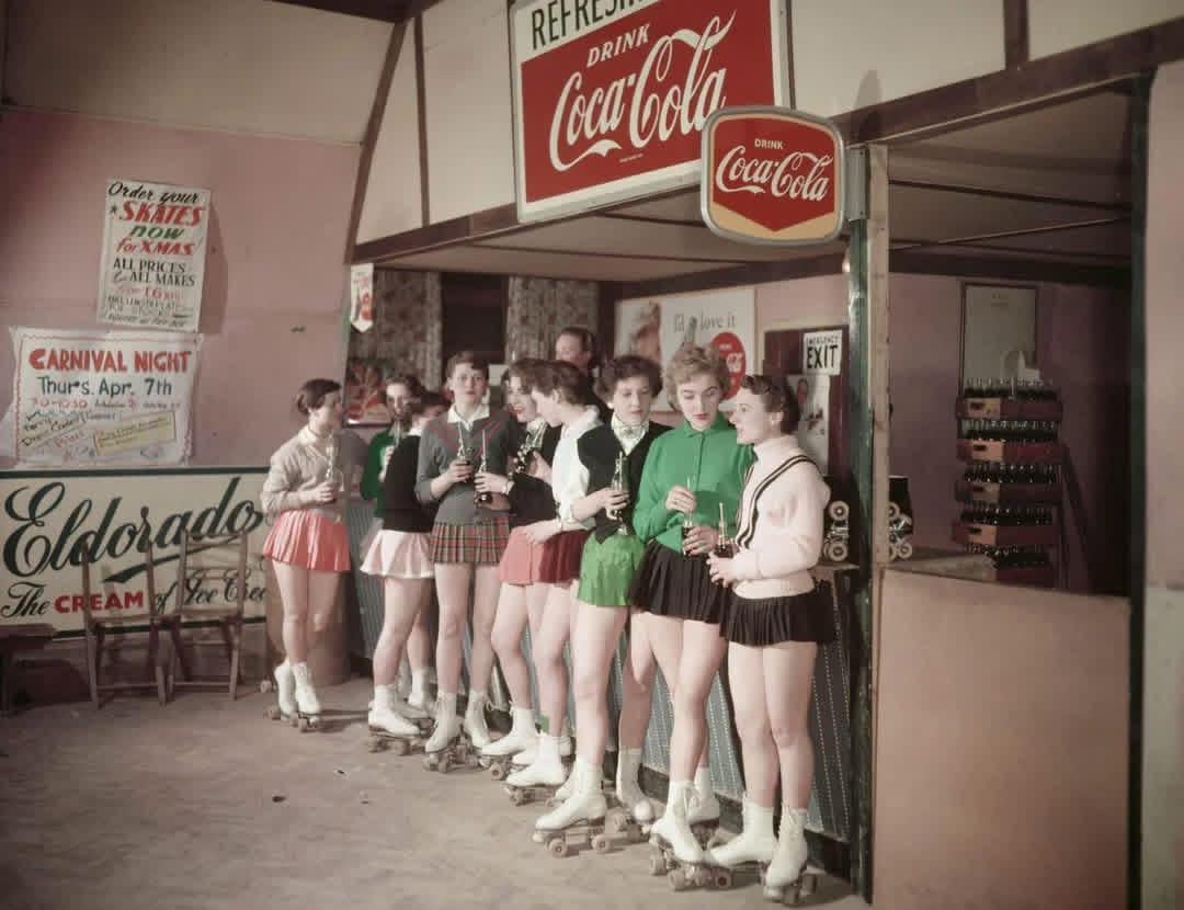 A group of young roller skaters stand at a counter of a cafe attached to a roller skating rink in Norwich, Norfolk, England. May 1955. [1080×830]
