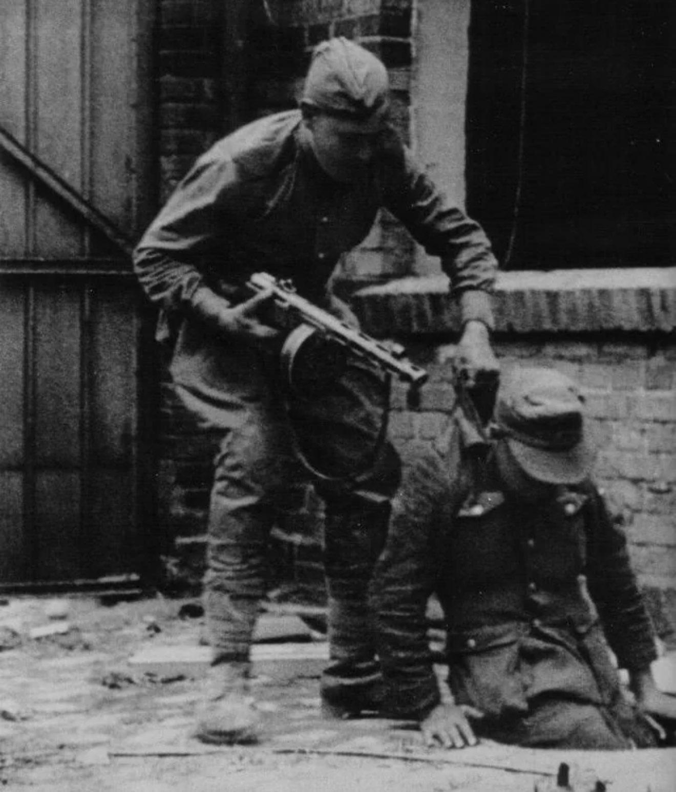 Soviet soldier with a PPSh-41 submachine gun, pulling a German soldier from a manhole, during the final days of the Battle of Berlin, c. April – May 1945. [1320 x 1548]