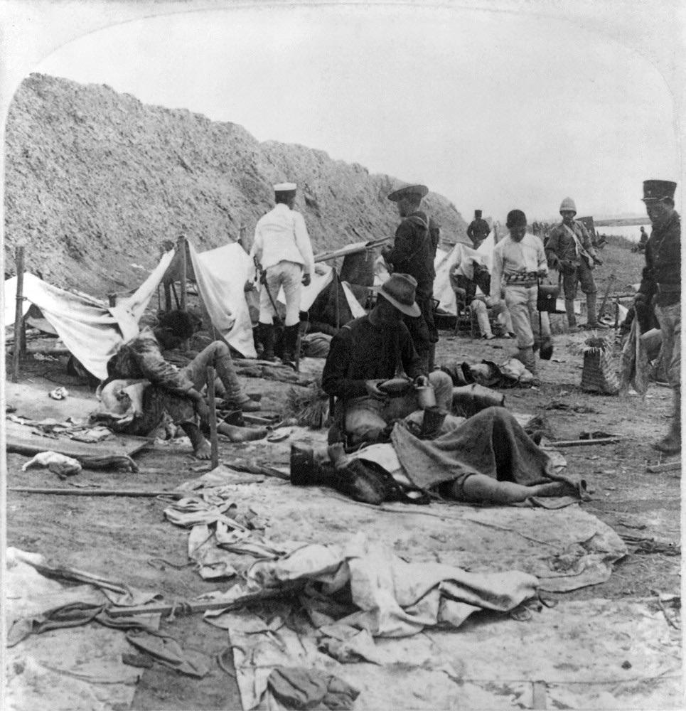 An American soldier gives water to a wounded Japanese ally after the Battle of Tianjin, China during the Boxer War. 1900. [965×1000]