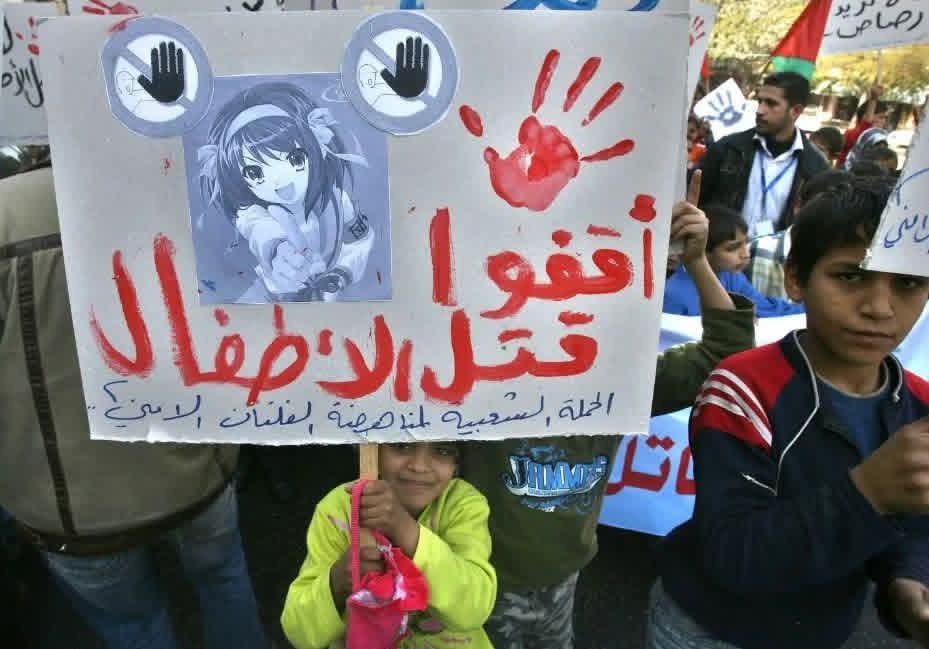 A picture of children protesting the killing of children in Gaza 20 years ago (13 December 2006) while holding up Haruhi Suzumiya. [929 × 649]