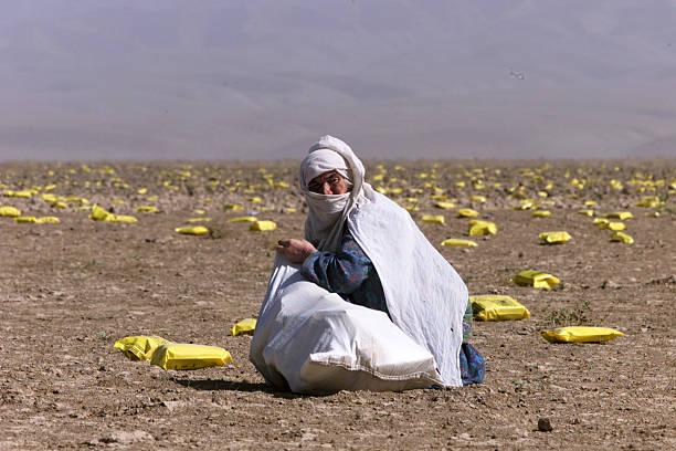 October 13th, 2001: Afghani woman picking-up the bags of supplies dropped by the American army. [612×612] (Photo by Patrick ROBERT)