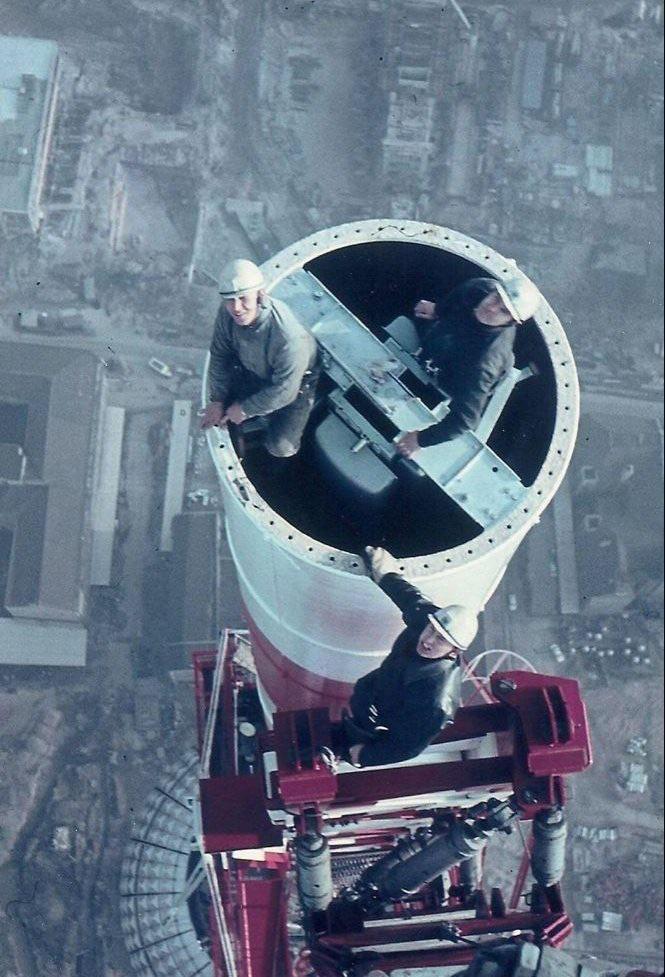 Three East German industrial workers standing on the Berlin Television Tower – in East Berlin, German Democratic Republic (GDR), c. late 1960s. [665 x 977]