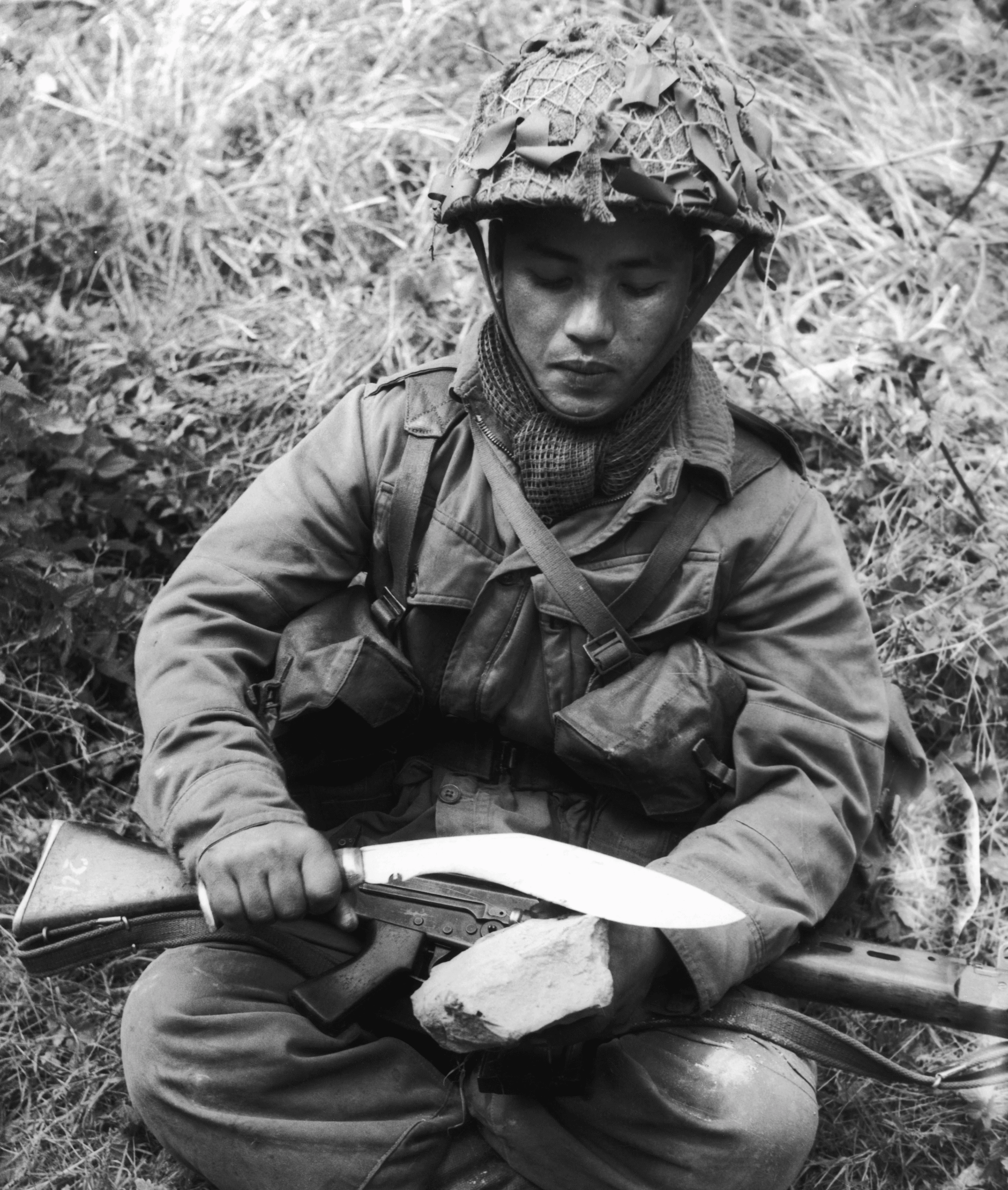 A Nepalese Gurkha rifleman sharpening his khukuri on Salisbury Plain, England, 1962 🏴󠁧󠁢󠁥󠁮󠁧󠁿 [3492 × 4122]