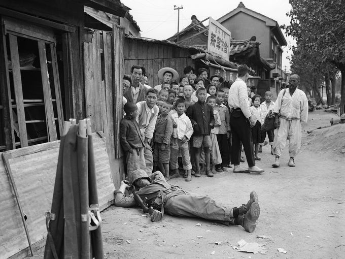 Seoul citizens looking at a U.S. Marine sleeping exhausted after the battle of 1950 [680 x 510]