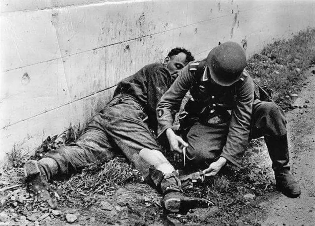 A German medic treating a wounded British soldier during the 1942 Dieppe raid. This photo was later used for propaganda [1070 x 767]