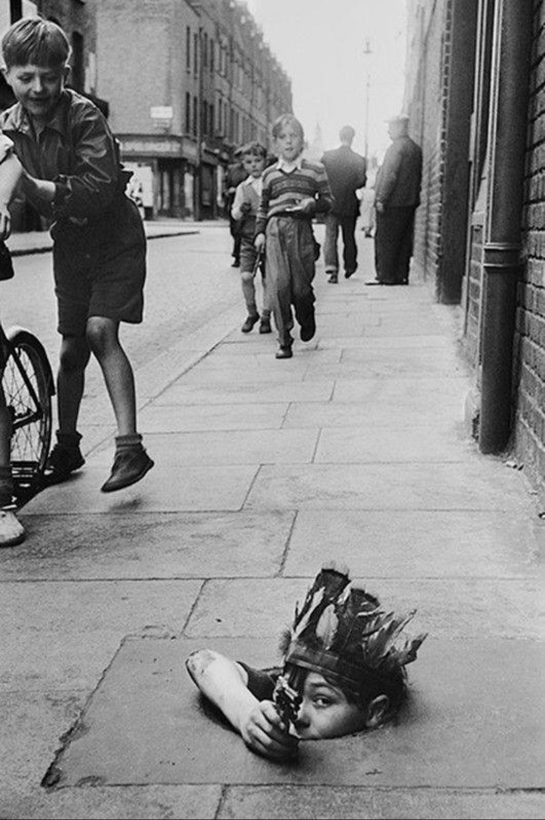 A boy hiding in a coal hole, Photo by Thurston Hopkins, 1954 [1080 x 1624]