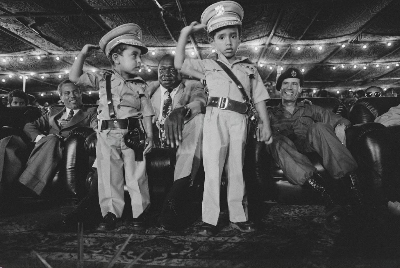 Ugandan leader Idi Amin and Libyan leader Muammar Gaddafi observe two of Gaddafi’s young sons, five-year-old Muhammad and three-year-old Saif al-Islam, 1975. [1376×923]