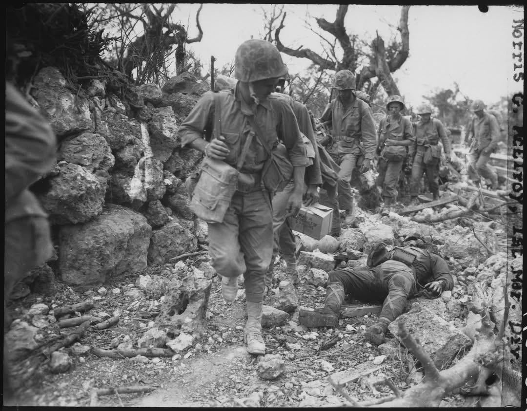 1st Division Marines pass through a small trail where Japanese soldiers lay dead during the Battle of Okinawa, April 1945. [1080×844]