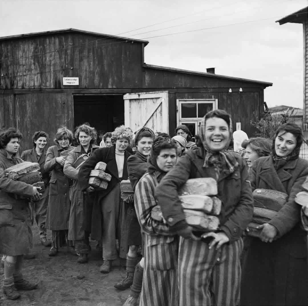 Liberated women inmates at the Bergen-Belsen Concentration Camp get loaves of bread from one of the five camp cookhouses – 24 April 1945. Sgt H. Oakes, Photographer. [1080×1074]